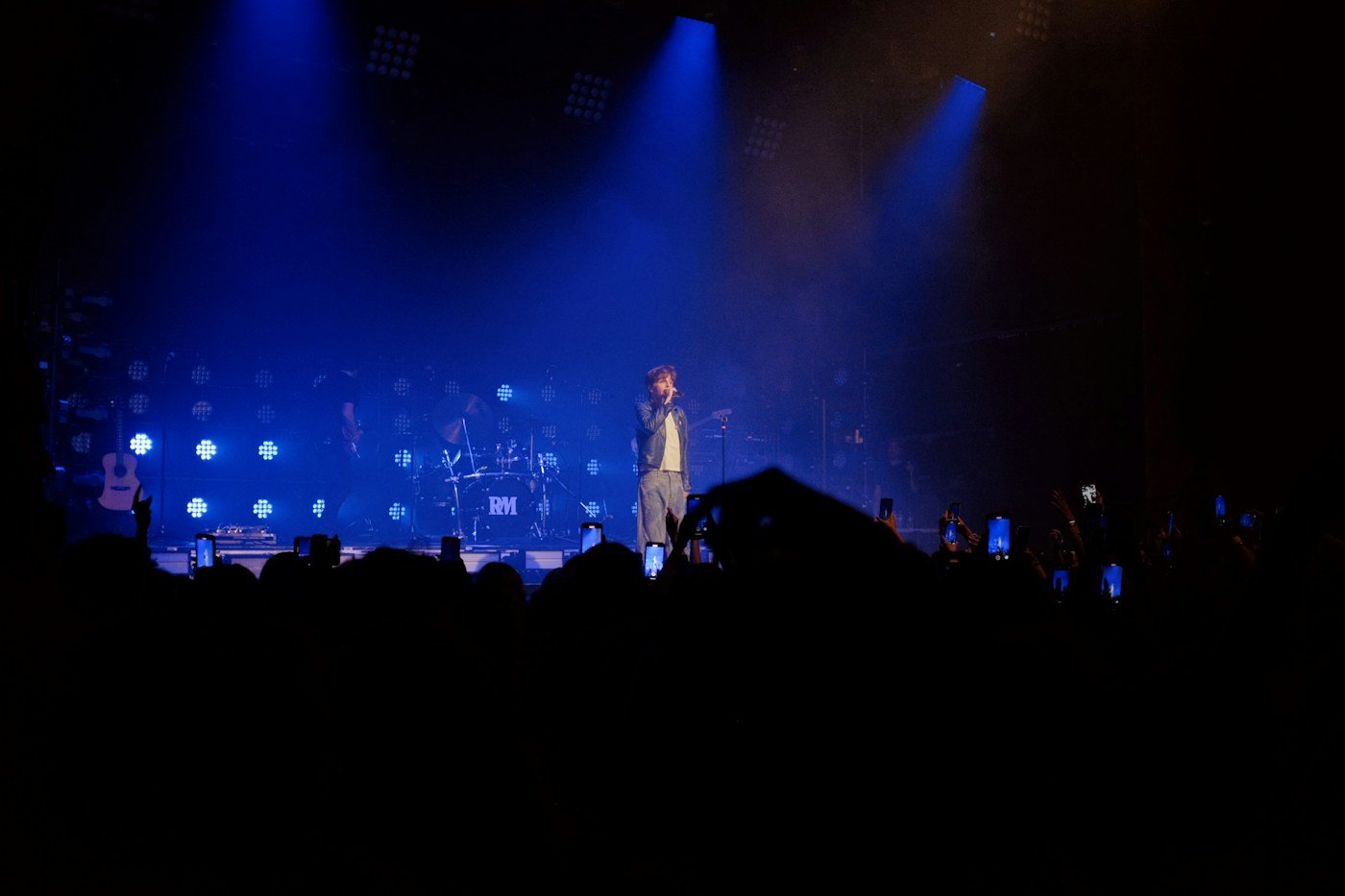 A live singer and band photographed from the audience